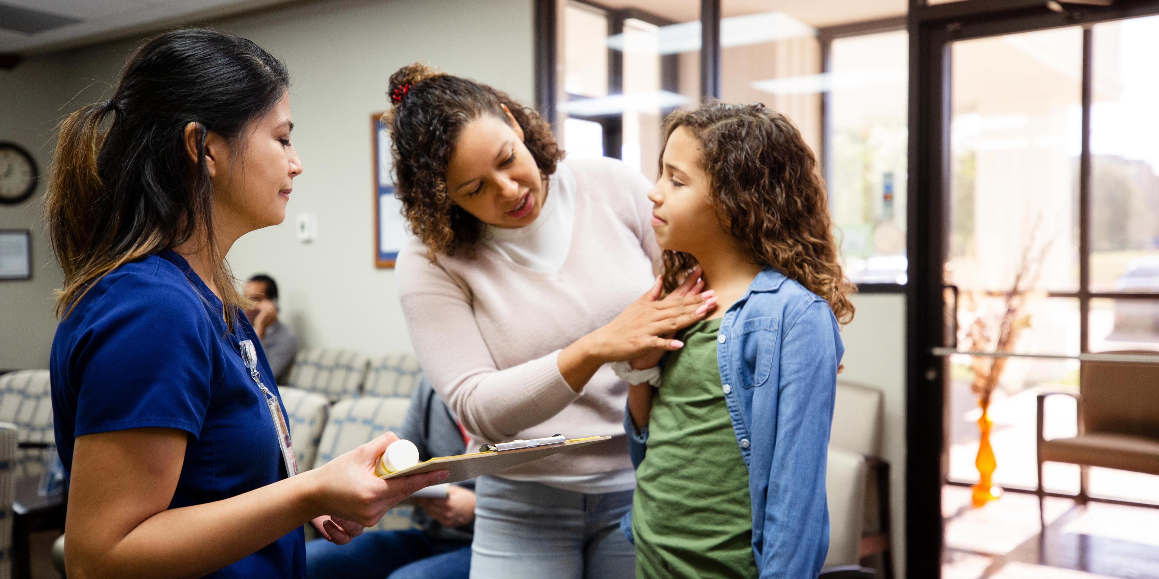 Mother discusses daughters symptoms with nurse 1207513987.jpg