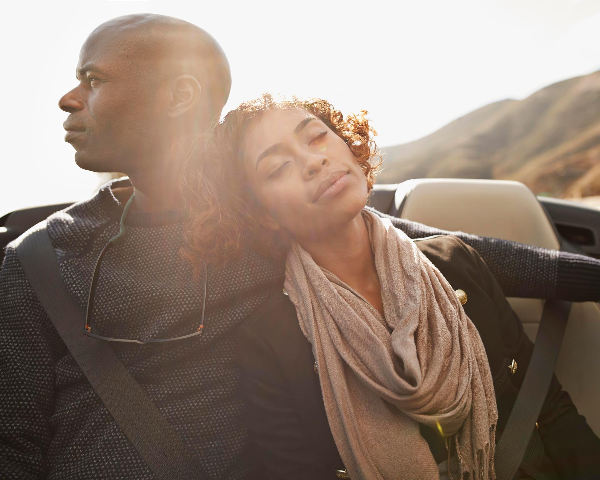 Couple relaxing on the backseat of convertible car-979457050.jpg