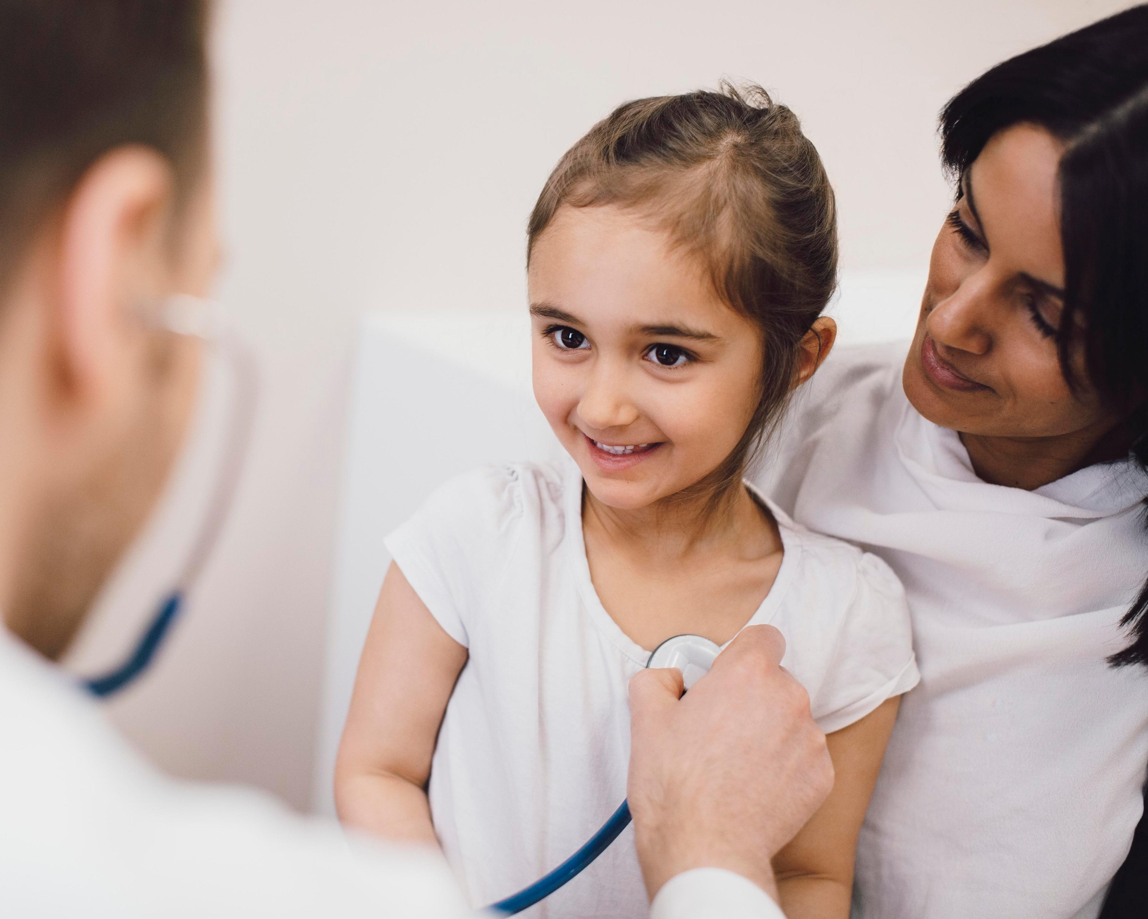 Male pediatrician checking girl