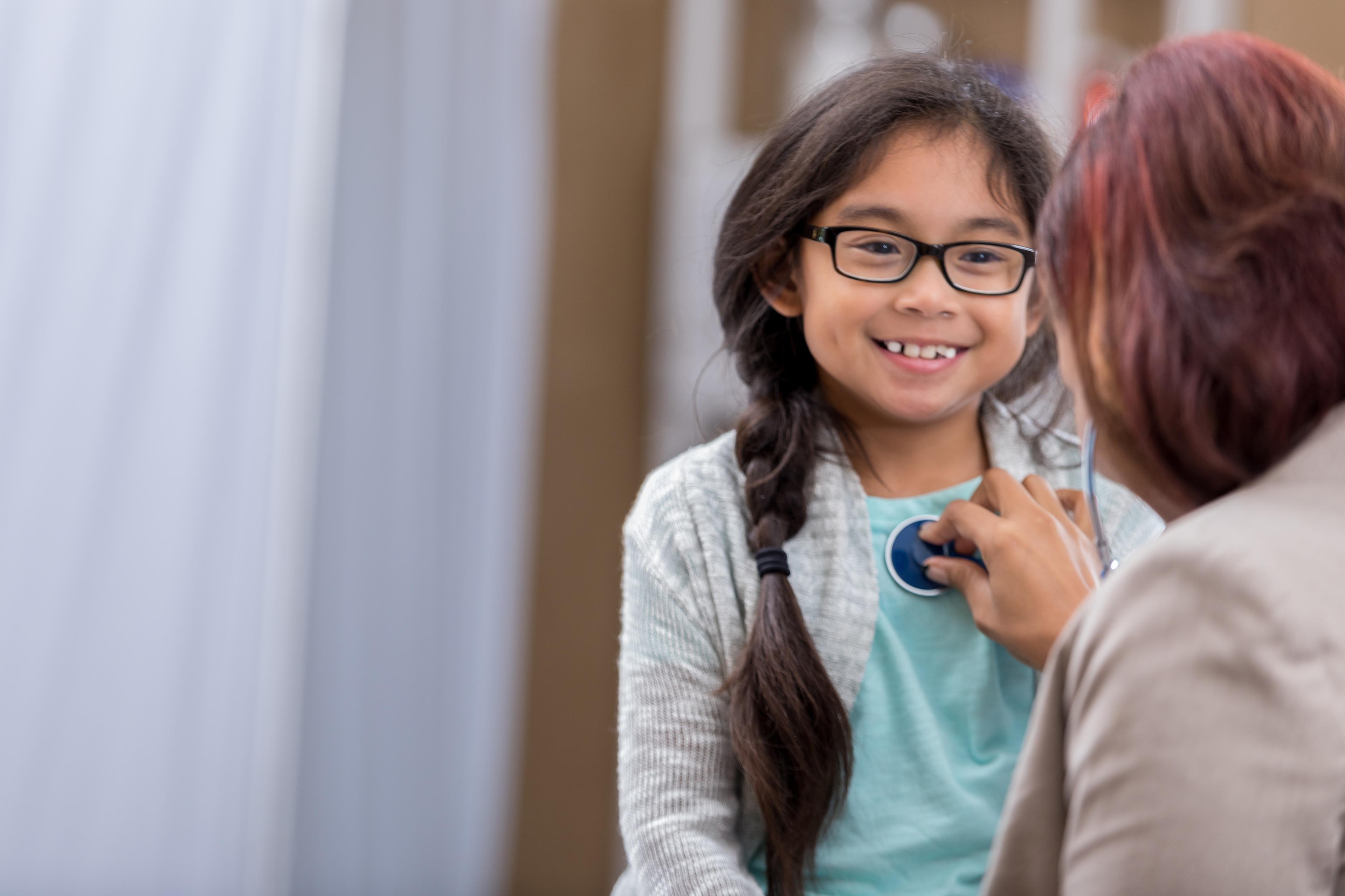 Female pediatrician listens to young patient's heartbeat 637014216.jpg